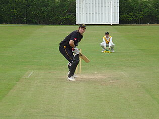A cricket player waiting to hit a ball.