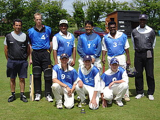 A cricket team dressed in blue.