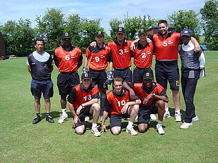 A cricket team dressed in red.