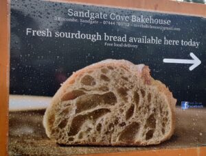 A picture of a sign with sourdough bread on made by The Sandgate Cove Bakery